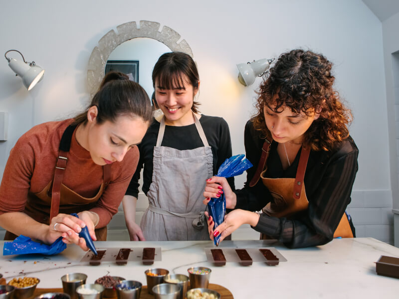 Three women making handmade chocolate bars from scratch