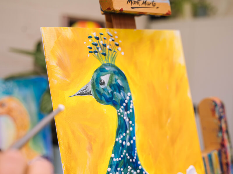 A painting of a blue peacock on canvas with a bright yellow background