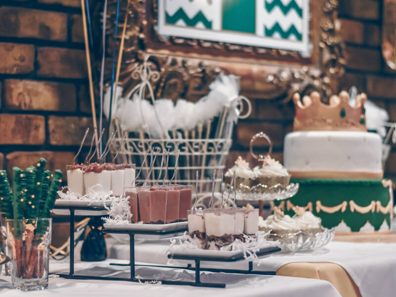 A baby shower event with a table laden with cakes and handmade decorations