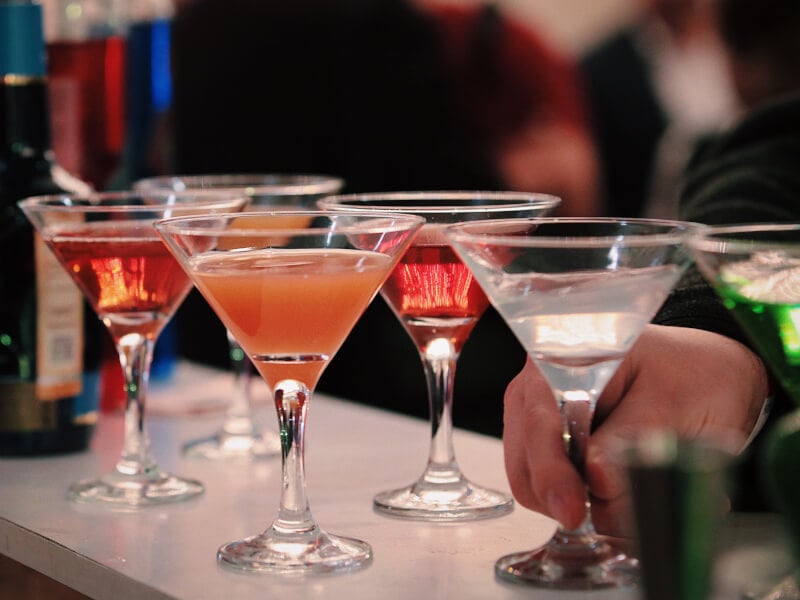 a row of cocktails in martini glasses