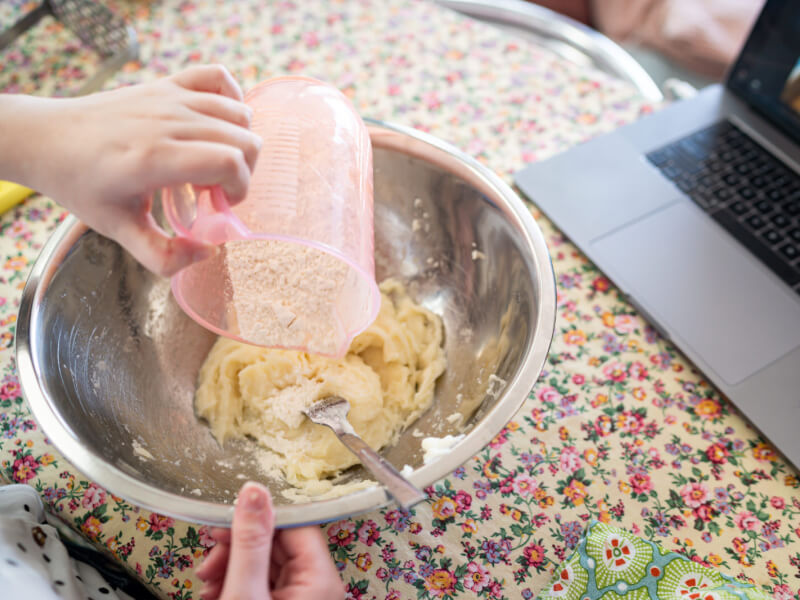 person mixing ingredients in a bowl at a virtual cooking class