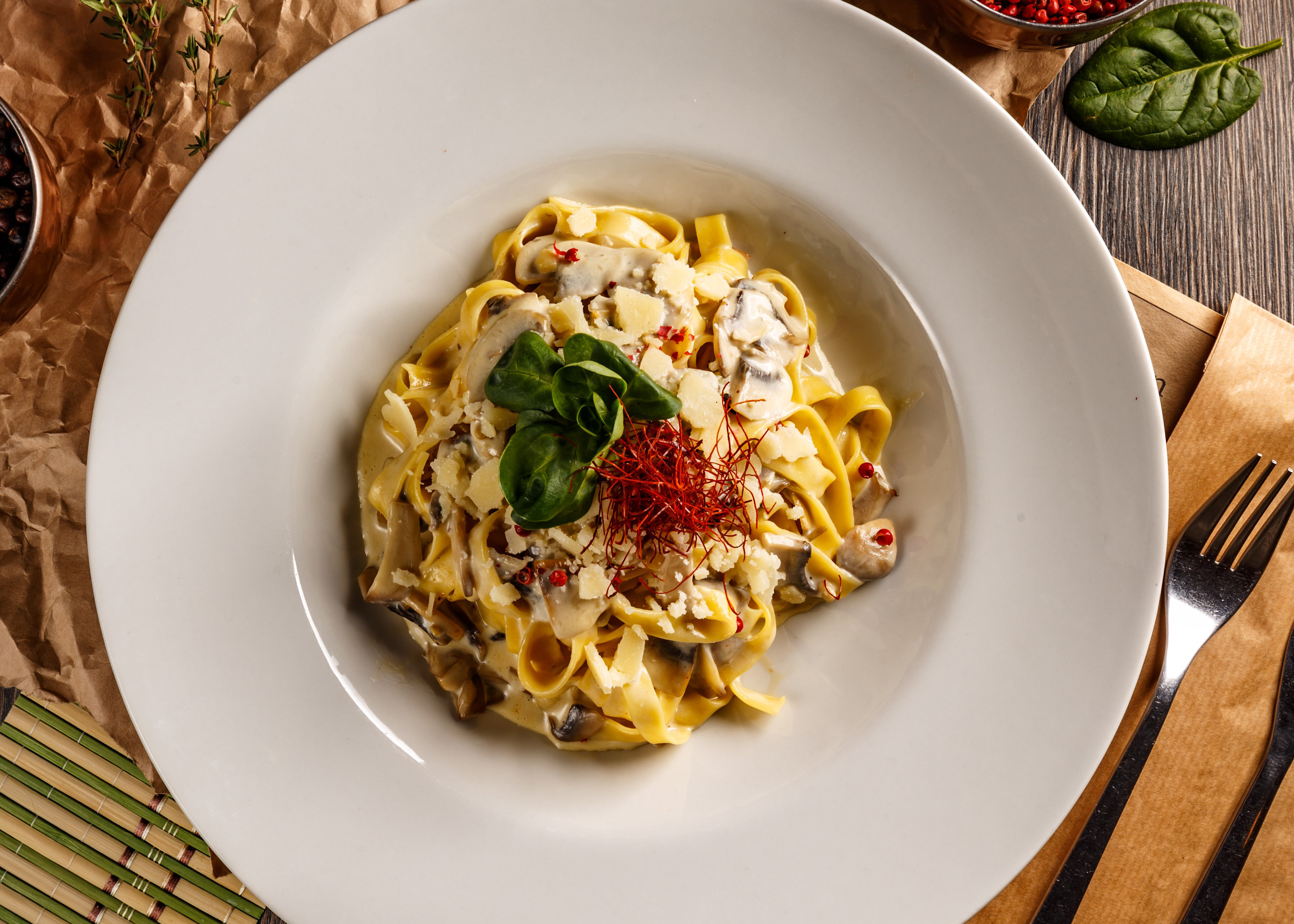 An Italian pasta dish in a large bowl sits on a wooden table