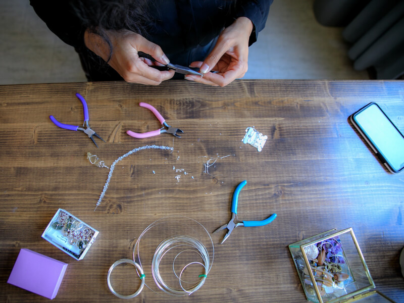 Person making DIY jewellery with pliers.
