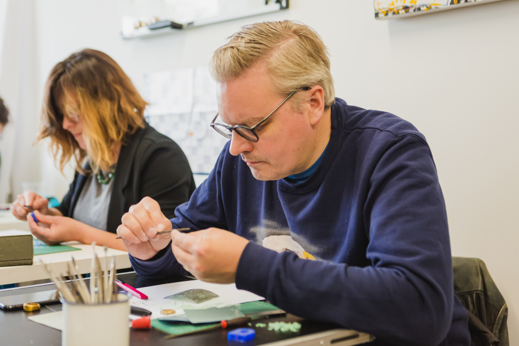 A man is carving a wax mold at a jewellery making workshop