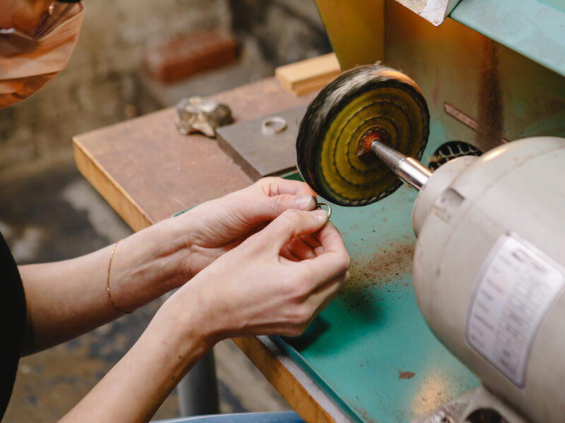 Someone making a ring in a silversmithing class