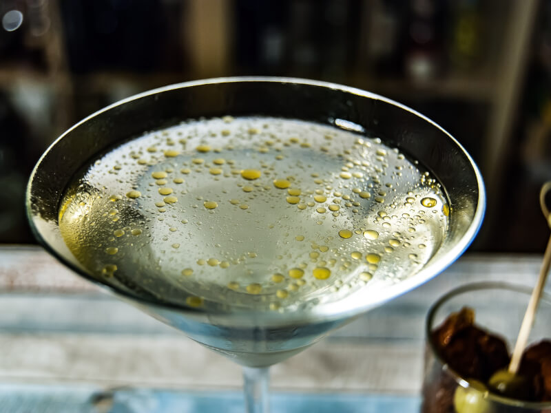DIY cocktail martini with drops of olive oil on the liquid's surface. 