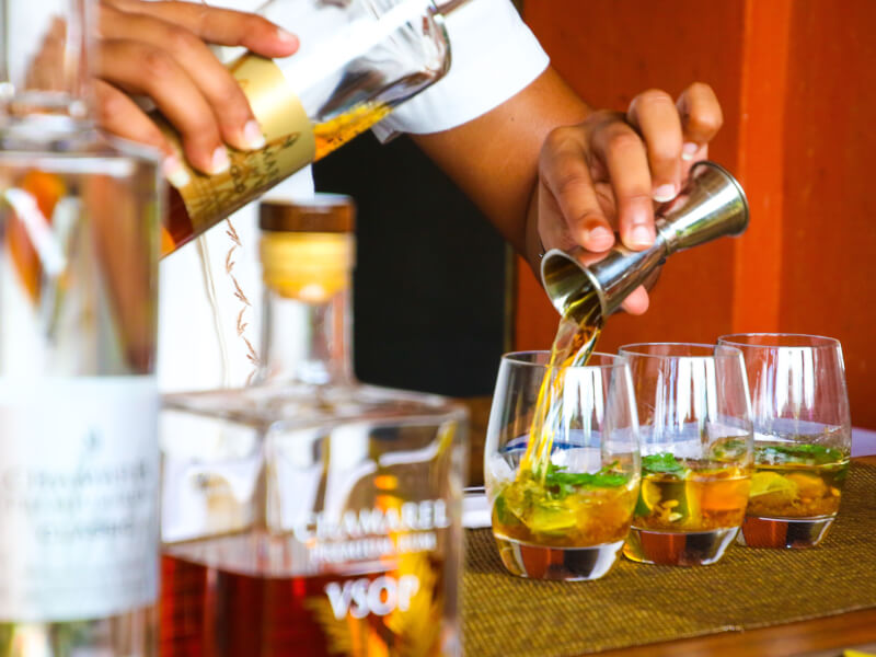 Person pouring shots during a cocktail making class.
