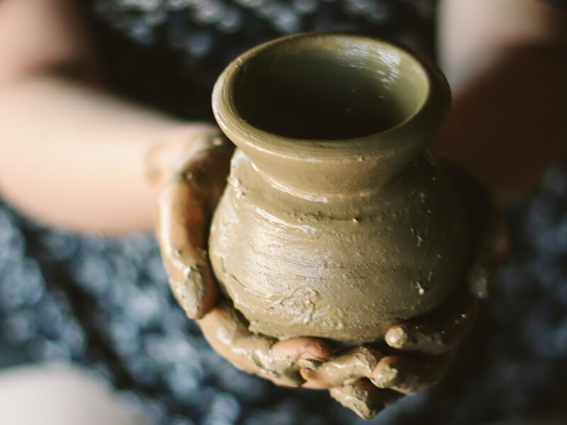 A person holding a handmade pottery vase