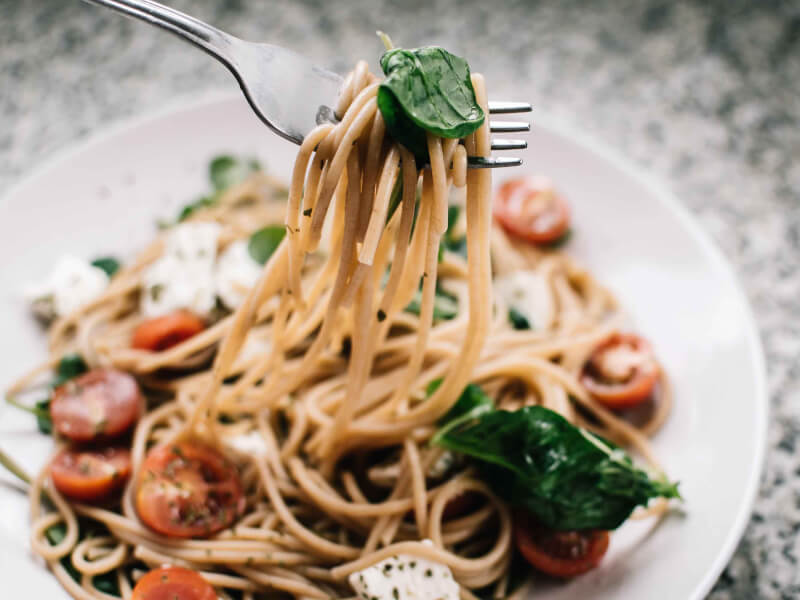 A traditional Italian pasta meal being picked up with a fork