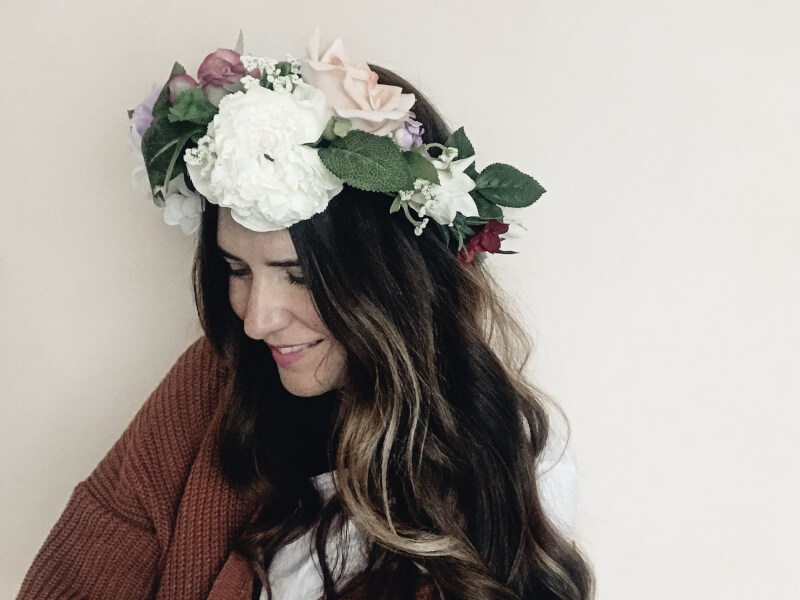 A woman in a brown sweater wearing a flower crown