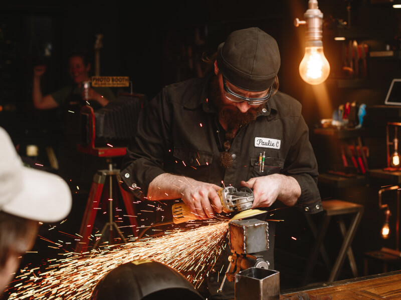A man is sanding metal at a welding class