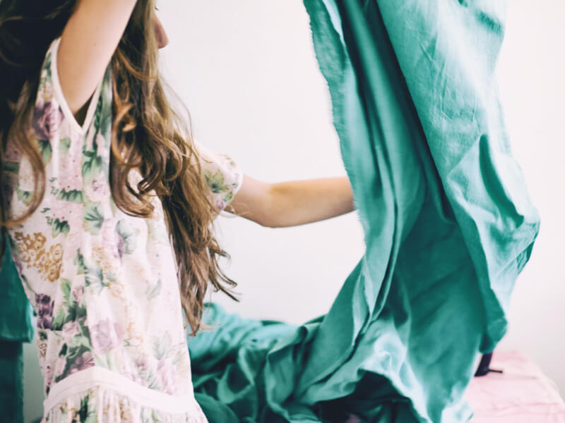 A person is shaking out turquoise fabric
