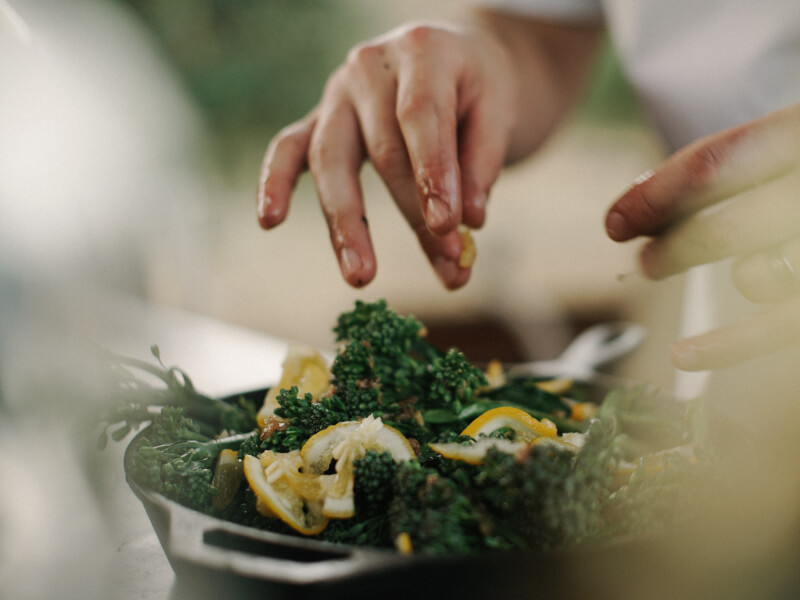 Saucepan of tenderstem broccoli and lemons from a cook at home kit.