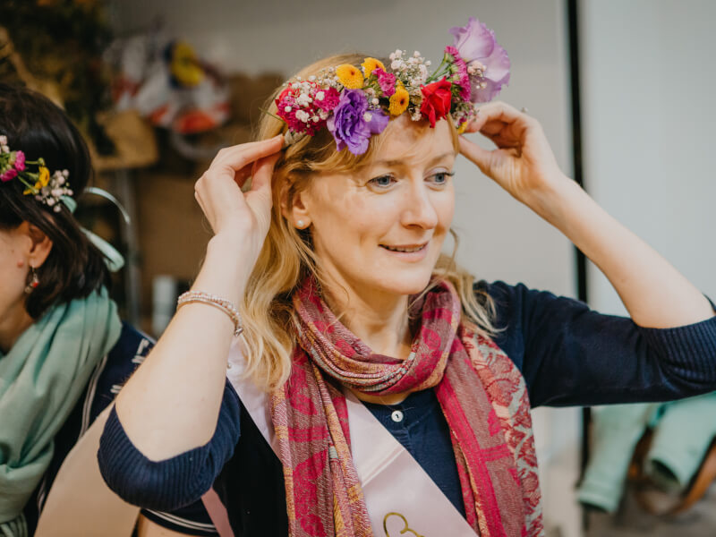 A woman is trying on a handmade floral crown