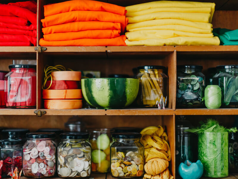 A picture of the shelves in the M.Y.O studio, full of coloured craft equipment 