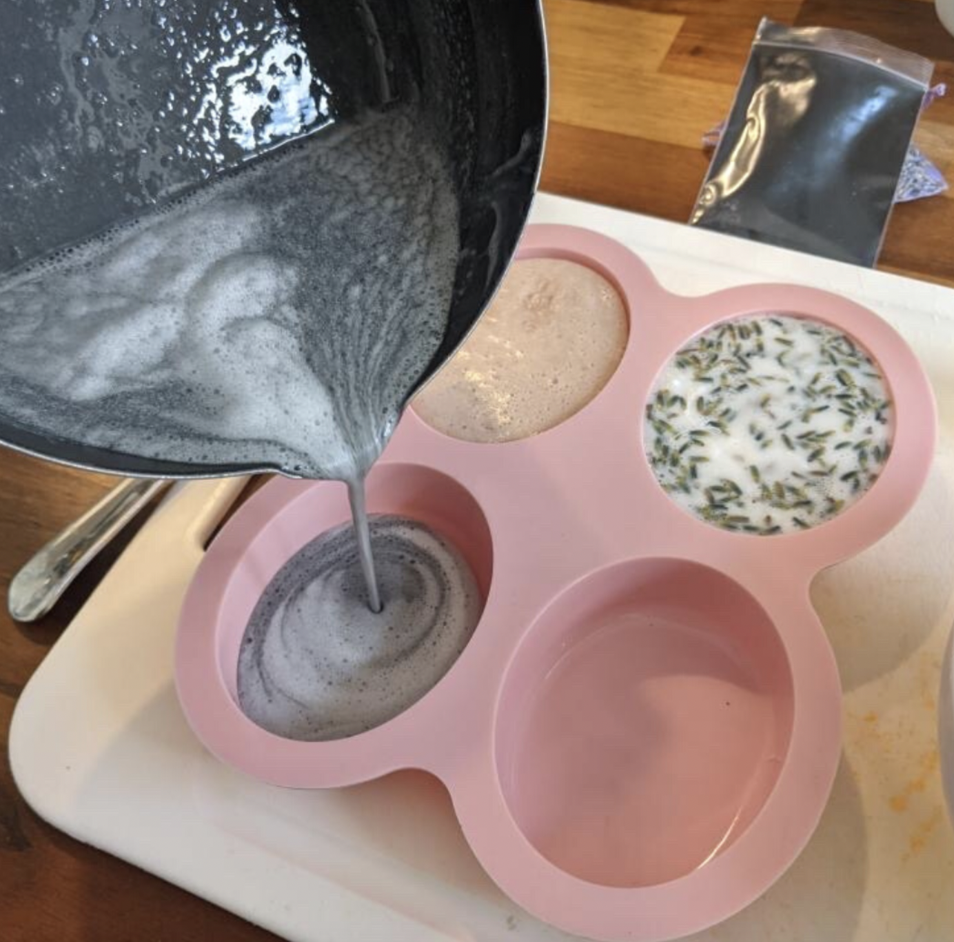 Pouring soap into pink soap mold.