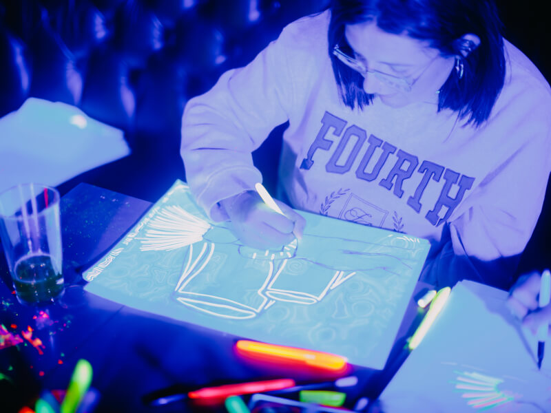 Woman painting with glow paints in a neon painting class