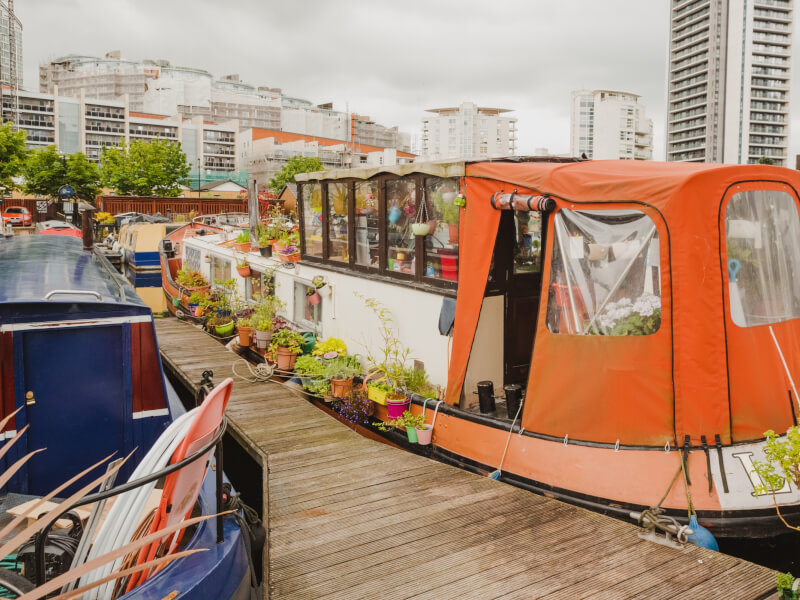 An orange houseboat covered in plants 
