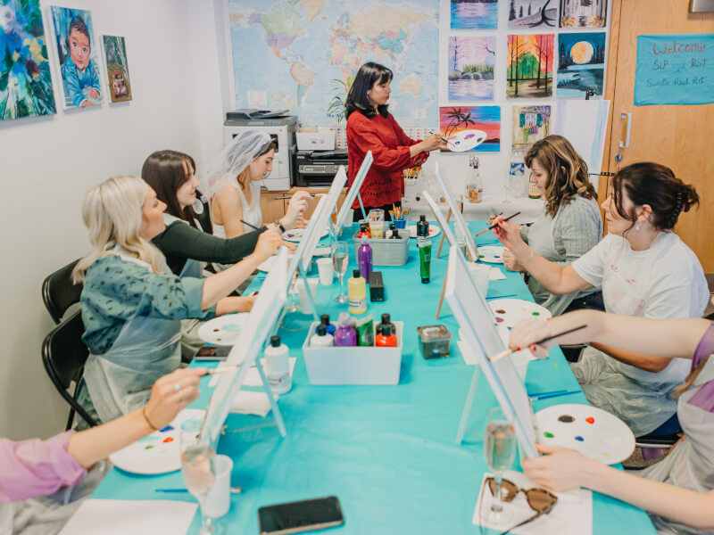 A group of women celebrating a hen party in a painting class