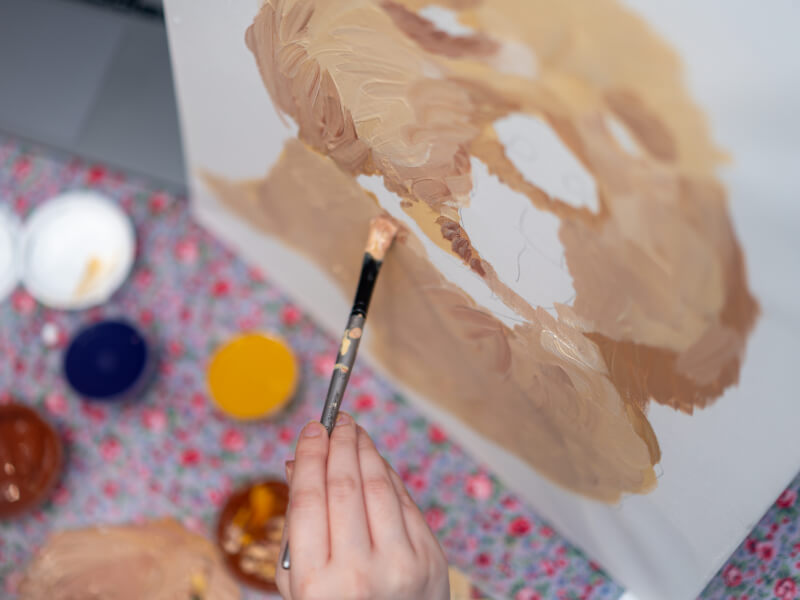 A close up of a person painting a dog portrait