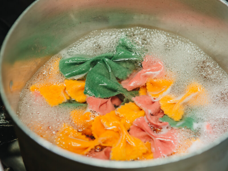 Colourful pasta shapes boiling in a pan. 