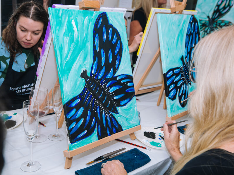 Several blue butterfly pictures painted on canvases at a paint and sip night