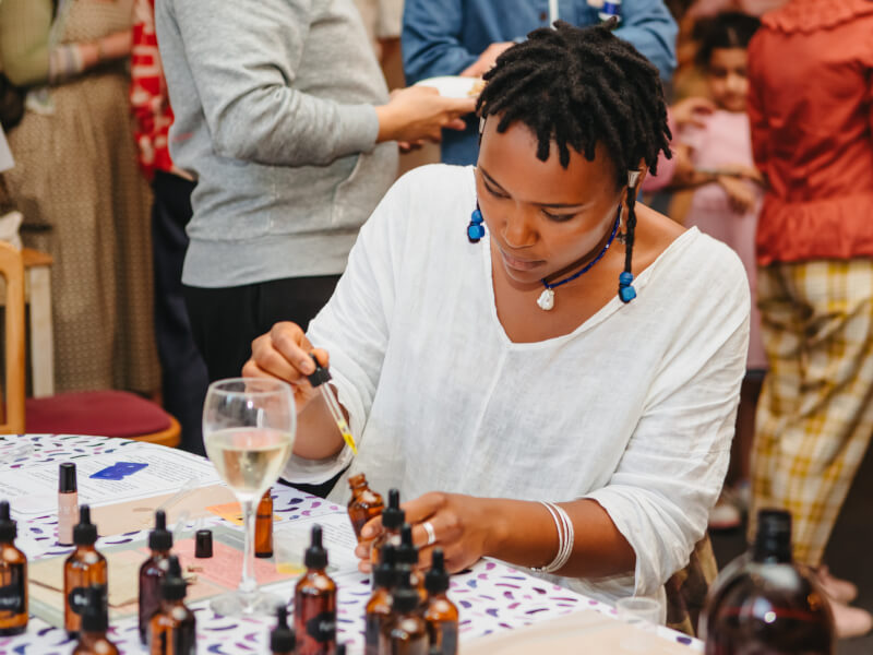 A woman at a perfume making classes is blending essential oils