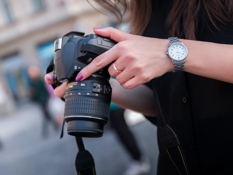 Side view, person checking the screen on a DSLR camera