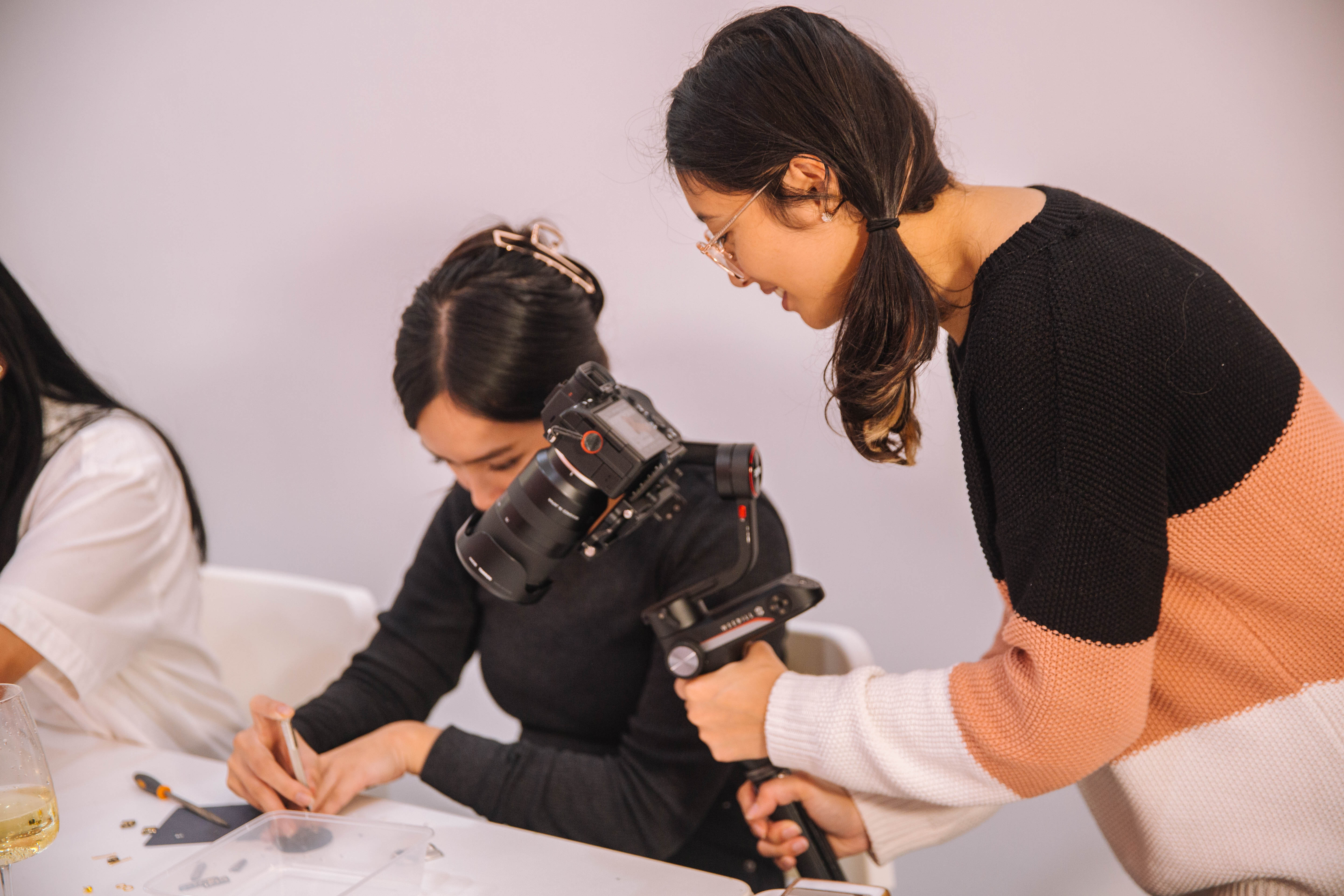 A person photographing a jewellery making class