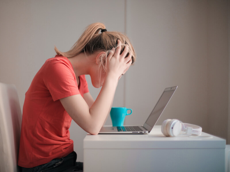 A person looking frustrated as they stare at their laptop