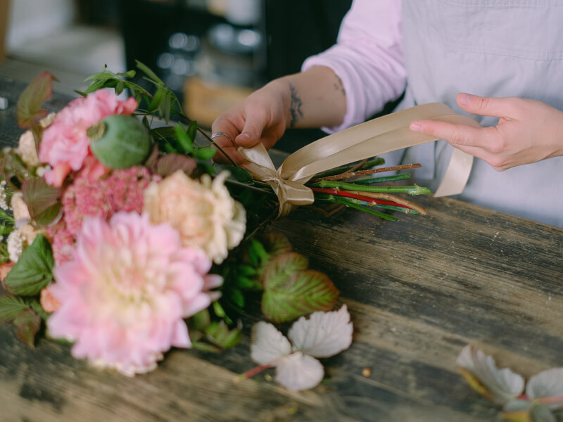 A woman arranging a flower bouquet.