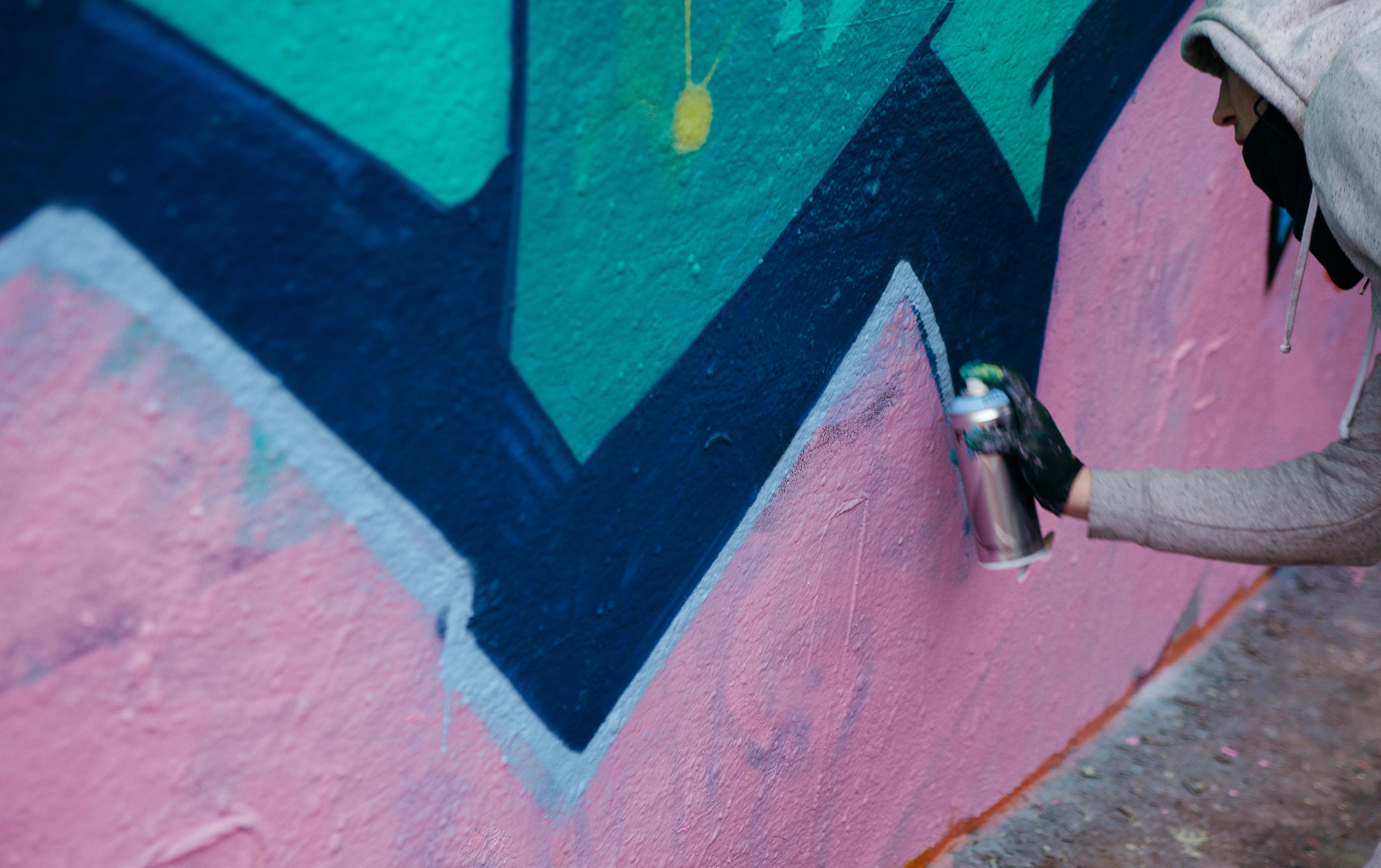 Close up of a person using a spraycan to make graffiti art