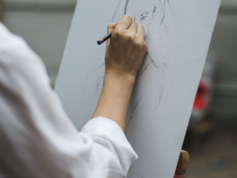 A person creating a life drawing on an art canvas