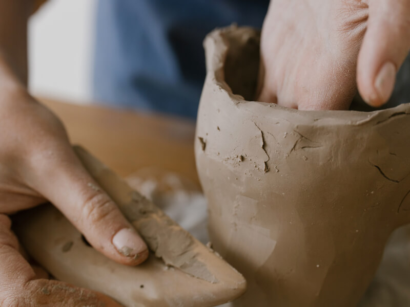 A person shaping a clay at a pottery class in Cambridge. 
