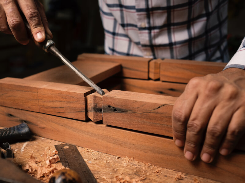 A hand putting a project together using woodworking tools.