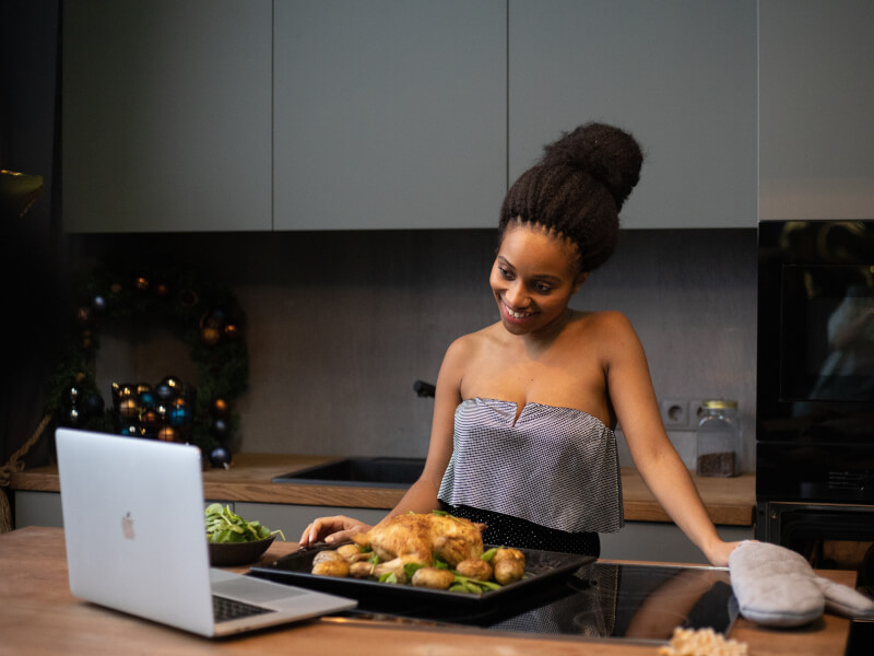 Woman smiling with the results of her roast dinner virtual cooking class.