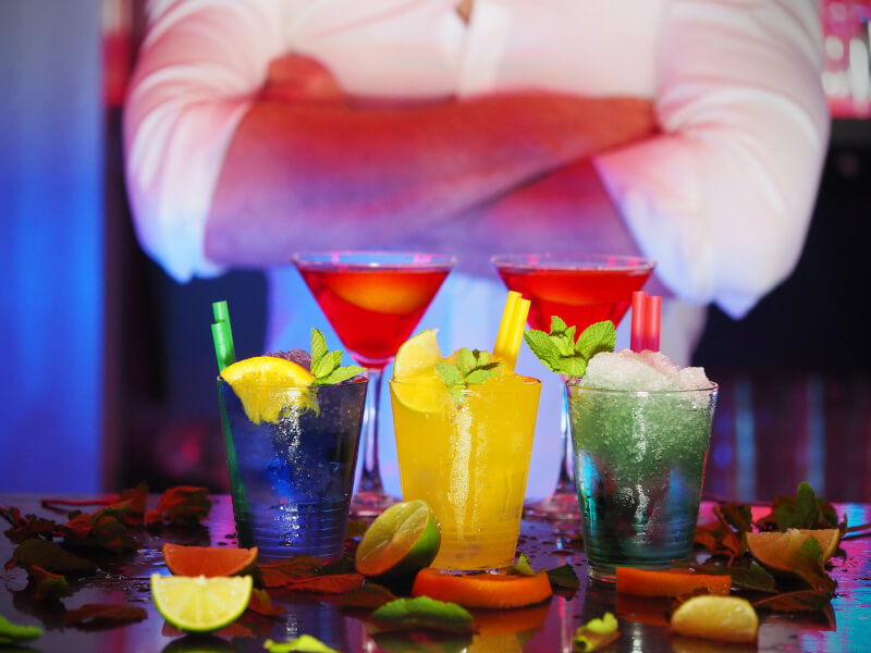 Five brightly coloured cocktails illuminated at a cocktail masterclass.