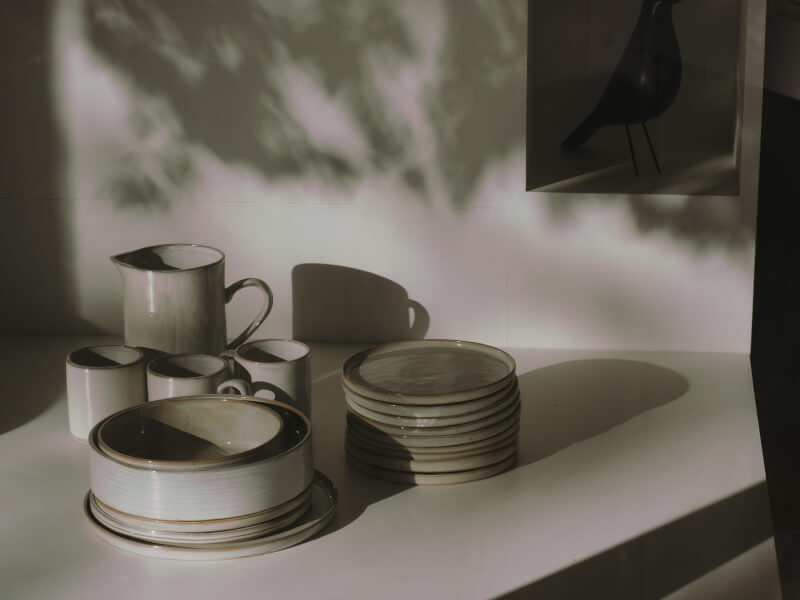 Several finished pottery plates and cups placed on a table