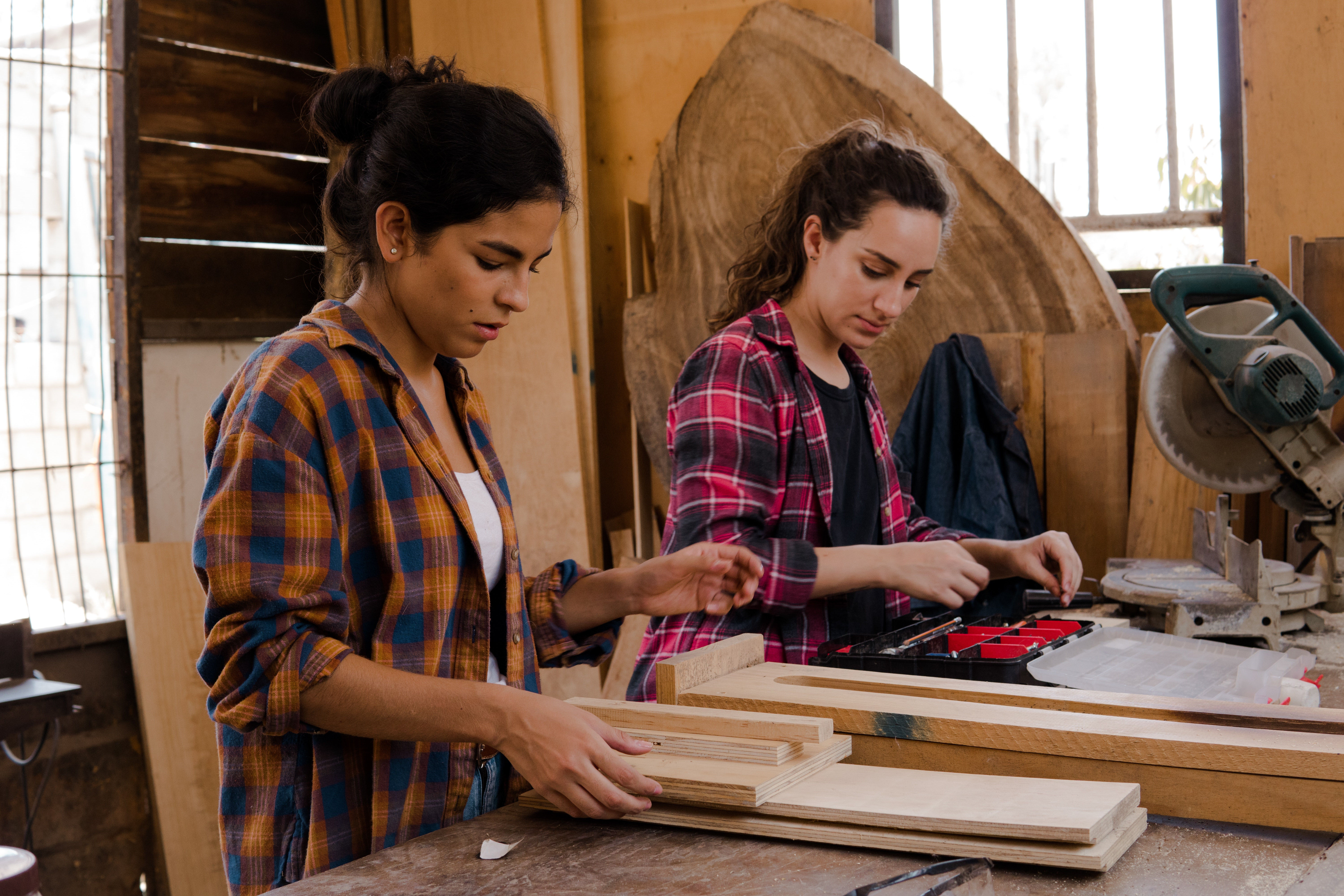 Two women enjoy a woodworking class.