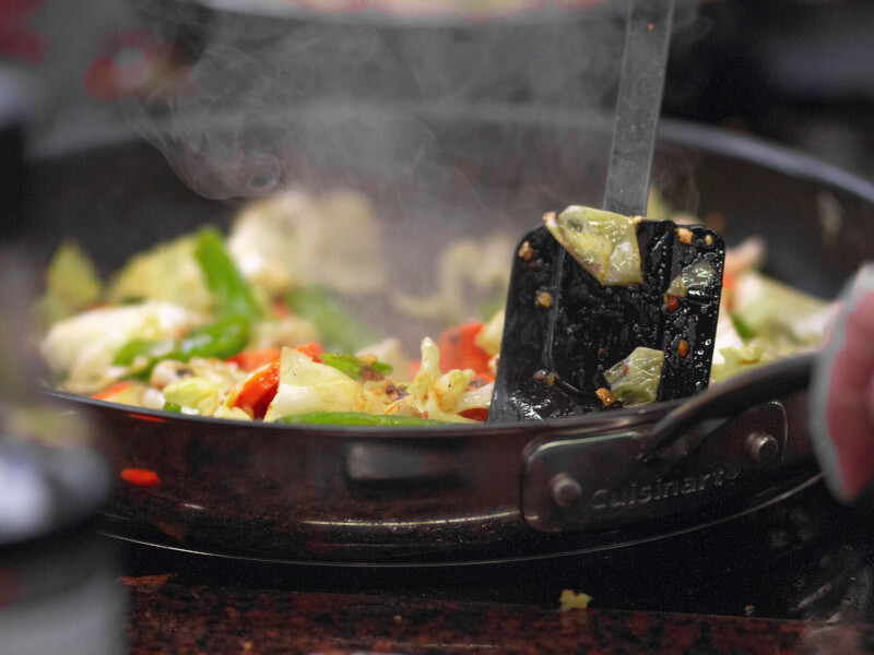 A spatula in a wok making a vegetable stir-fry. 