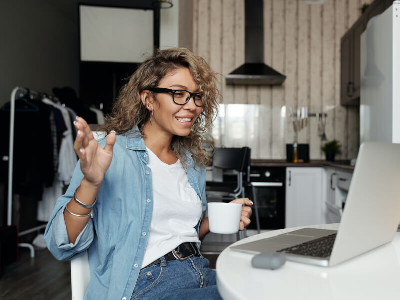 A person concentrating and smiling as they look at their laptop
