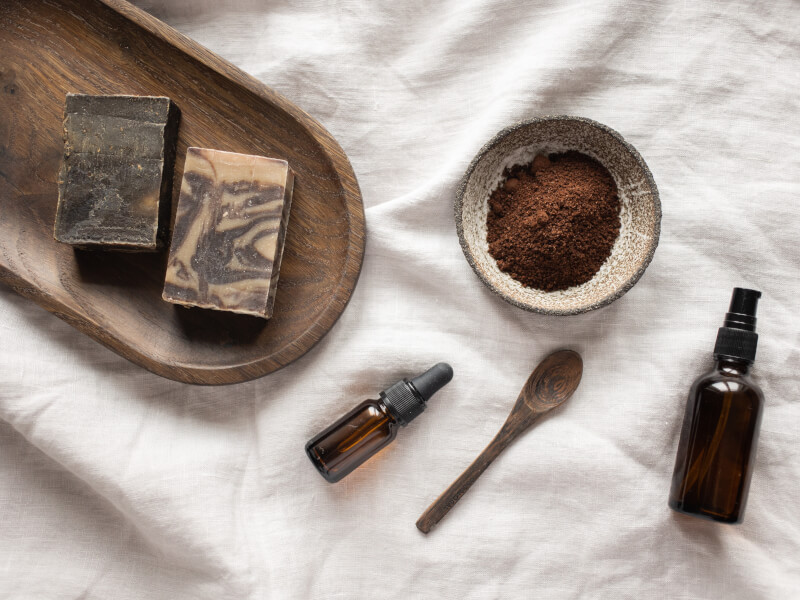 Some brown handmade natural soap bars sit on a wooden tray