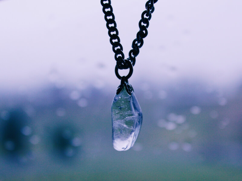 A glass pendant hangs from a black DIY necklace. 