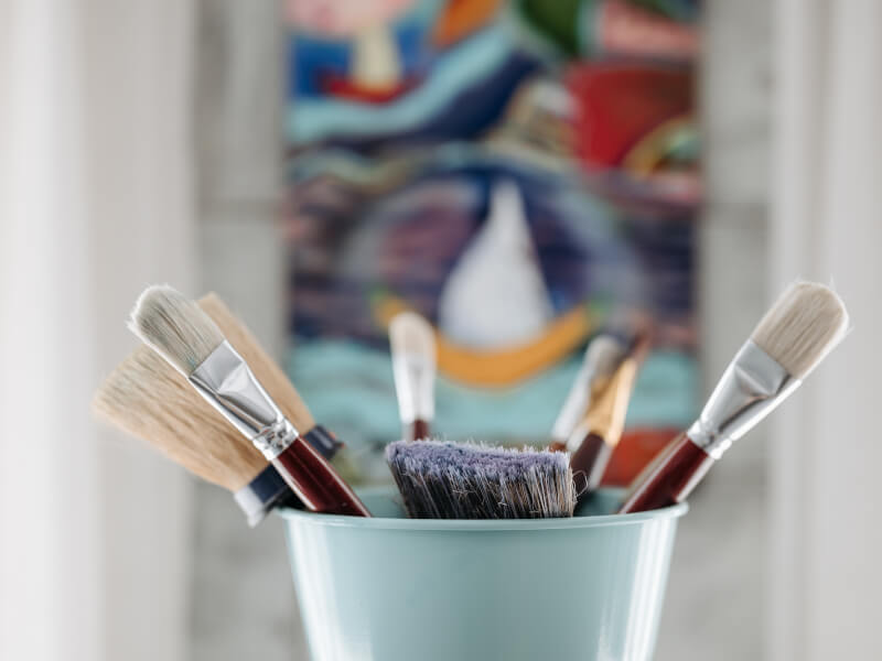 A closeup of paintbrushes in a pot.