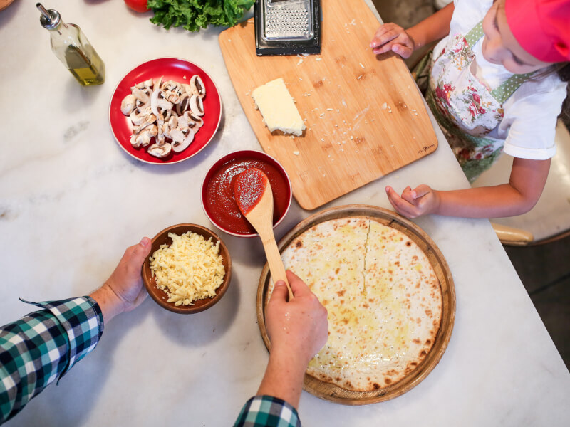 A family making a pizza from scratch