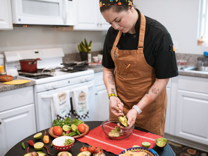 Person chopping vegetables at vegan cooking class.