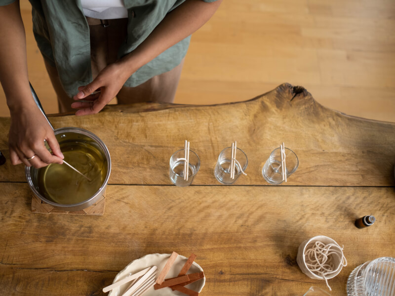 Birds-eye view of a person making handmade soy wax candles.