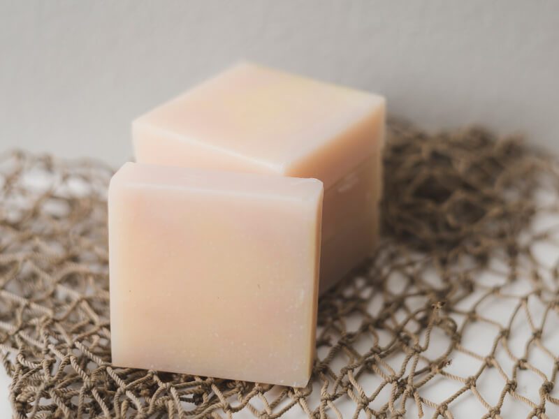 Slices of homemade soap sit on top of some rope netting.