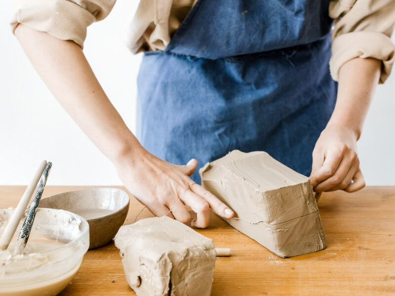Person moulding clay at a pottery class in London.