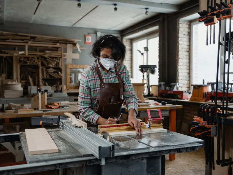 A person measures a piece of wood to use in a DIY craft project.